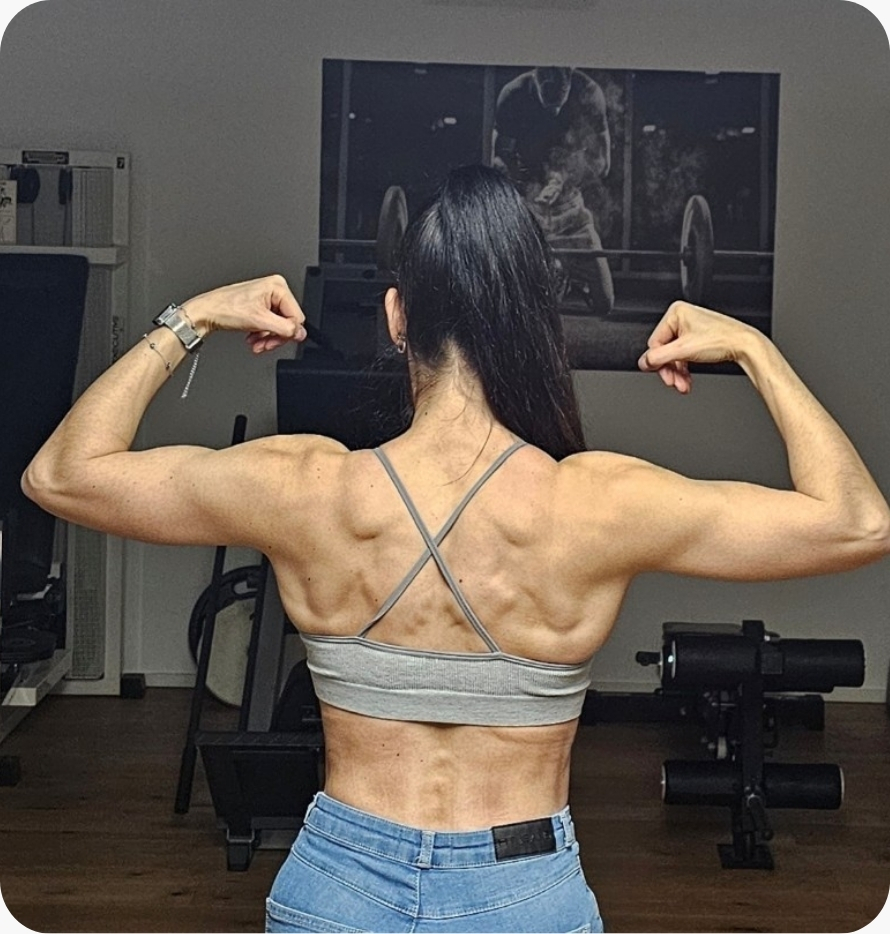 Trainierte Frau im Fitnessstudio von hinten – Rücken- und Gesäßmuskulatur definiert