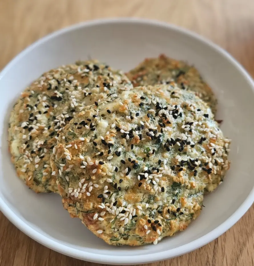 Goldbraune glutenfreie Börek-Taler mit Feta, Haferflocken und frischen Kräutern, proteinreich und ofengebacken