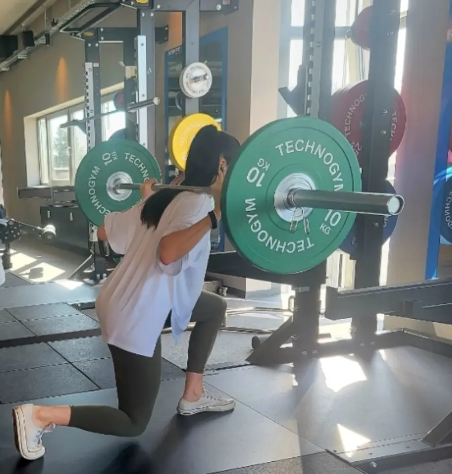 Frau mit Hanteln und geöffneter Blume – Symbol für Stärke und Balance